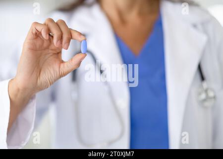 Die Ärztin hält eine medizinische Pille in der Hand Stockfoto