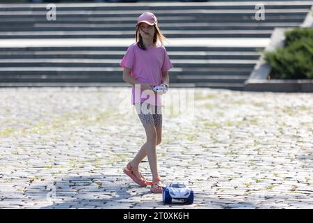 Mädchen spielt mit Fernbedienungswagen Stockfoto