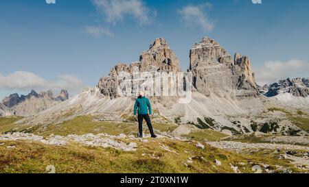 Inmitten der Pracht der Berge steht ein einsamer Mann als Zeugnis menschlichen Geistes und Abenteuers. Stockfoto