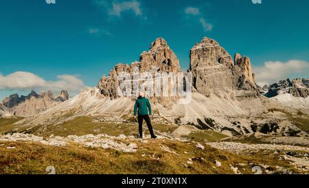 Inmitten der Pracht der Berge steht ein einsamer Mann als Zeugnis menschlichen Geistes und Abenteuers. Stockfoto