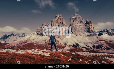 Inmitten der Pracht der Berge steht ein einsamer Mann als Zeugnis menschlichen Geistes und Abenteuers. Stockfoto