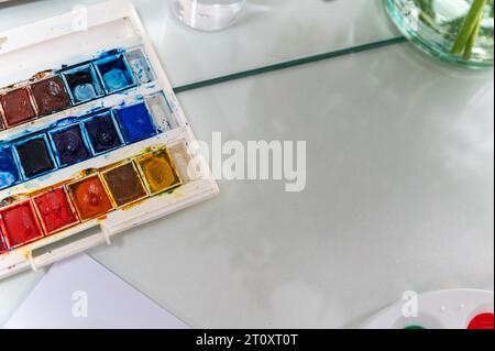 Dieses Nahaufnahme-Foto zeigt eine Aquarellpalette. Die Palette ist so angeordnet, dass sie aussieht, als würde sie in einem Gemälde verwendet. Stockfoto