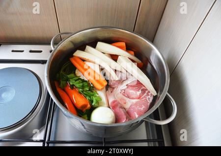 Zutaten für Rindersuppe im Topf. Fleisch, frisches Gemüse und Kräuter zum Kochen von Rindersuppe. Stockfoto