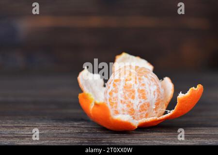 Geschälte Mandarine auf hölzernem Hintergrund mit Kopierraum Stockfoto