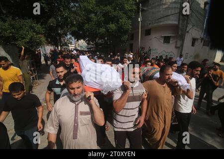 Gaza-Stadt. Oktober 2023. Menschen tragen Leichen von Palästinensern, die bei einem israelischen Luftangriff am 9. Oktober 2023 in Rafah im südlichen Gazastreifen starben. Die Zahl der Todesopfer und Verletzten infolge israelischer Angriffe auf den Gazastreifen ist laut der jüngsten Aktualisierung des palästinensischen Gesundheitsministeriums am Montag auf 687 bzw. 3.726 gestiegen. Die Zahl der Todesopfer durch den Überraschungsangriff der Hamas auf Südradisel stieg auf über 900, berichtete Israels staatseigenes Kan TV am Montag. Quelle: Xinhua/Alamy Live News Stockfoto