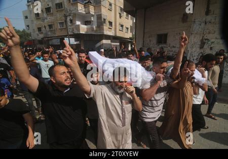 Gaza-Stadt. Oktober 2023. Menschen tragen Leichen von Palästinensern, die bei einem israelischen Luftangriff am 9. Oktober 2023 in Rafah im südlichen Gazastreifen starben. Die Zahl der Todesopfer und Verletzten infolge israelischer Angriffe auf den Gazastreifen ist laut der jüngsten Aktualisierung des palästinensischen Gesundheitsministeriums am Montag auf 687 bzw. 3.726 gestiegen. Die Zahl der Todesopfer durch den Überraschungsangriff der Hamas auf Südradisel stieg auf über 900, berichtete Israels staatseigenes Kan TV am Montag. Quelle: Xinhua/Alamy Live News Stockfoto