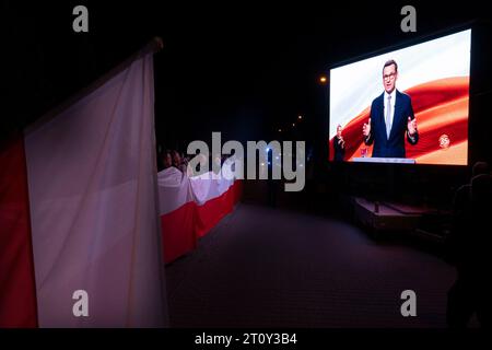 Anhänger der Partei Recht und Gerechtigkeit beobachten die Wahldebatte vor dem Fernsehstudio am 9. Oktober 2023 in Warschau, Polen. Der Organisator der Wahldebatte, der öffentlich-rechtliche Sender TVP, hat alle Medien wegen des Platzmangels am Veranstaltungsort nicht akkreditiert. Medien, denen die Akkreditierung verweigert wurde, veröffentlichten E-Mails von TVP, die eine identische Nachricht an alle Betroffenen enthielten. Der öffentlich-rechtliche Rundfunk wurde sowohl im in- als auch im Ausland wegen seines mangelnden Gleichgewichts vielfach kritisiert und wird allgemein als Sprachrohr der Regierung angesehen. (Foto: Jaap Arriens/SIPA USA) Stockfoto