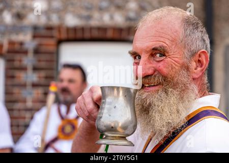 Ein Morris Dancer aus der Brighton Morris Side trinkt Bier aus Einem traditionellen Tankard beim jährlichen „Dancing in the Old“ Event in Lewes, Sussex, Großbritannien Stockfoto