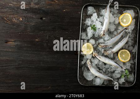 Gefrorener Shisamo-Fisch auf Holztisch, Blick von oben. Kopierbereich für Text Stockfoto