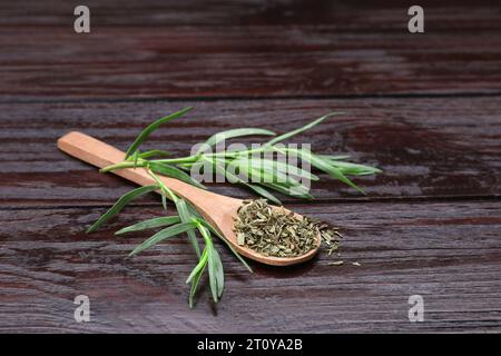 Löffel Estragon und grüne Blätter auf Holztisch Stockfoto