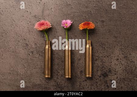 Schöne Blumen in Kugeln auf grauem, strukturiertem Tisch, flach gelegen Stockfoto