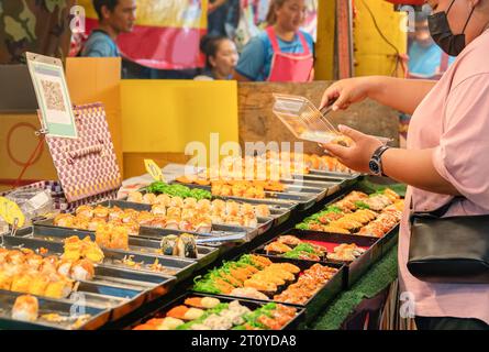 Wählen Sie ein japanisches Sushi-Essen. Auf dem Street Food Markt. Maki und Brötchen, Lachs, Garnelen, Krabben. Stockfoto