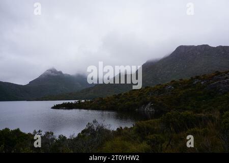 Dramatisch bewölkter, stimmungsvoller Blick auf die Landschaft mit niedrigen, hängenden Wolken über dem Dove Lake, Cradle Mountain, Tasmanien, Australien Stockfoto