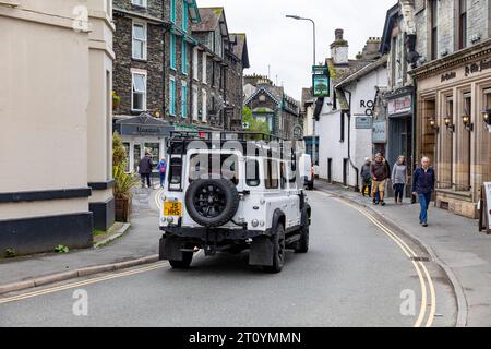 Land Rover Defender 100 White Fahrt durch Ambleside Stadtzentrum, Lake District, Cumbria, England, Großbritannien Stockfoto
