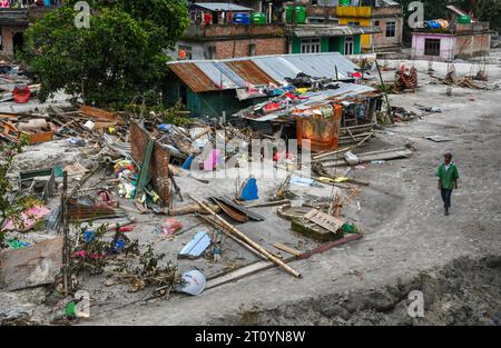 Rangpo, Indien. Oktober 2023. Ein Mann läuft an überfluteten Häusern im Hochwassergebiet entlang des Teesta River vorbei. Nachdem ein Gletschersee im Nordosten Indiens kurz nach Mitternacht durch einen Damm platzte, Häuser und Brücken wegspülte und Tausende zur Flucht zwang, gruben die Rettungskräfte weiter durch Schlammschutt. Quelle: SOPA Images Limited/Alamy Live News Stockfoto