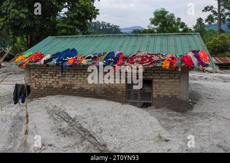 Rangpo, Indien. Oktober 2023. Die Kleidung wird auf dem Dach des Hauses trocken gehalten, das durch die Überschwemmungen entlang des Teesta River teilweise beschädigt wurde. Nachdem ein Gletschersee im Nordosten Indiens kurz nach Mitternacht durch einen Damm platzte, Häuser und Brücken wegspülte und Tausende zur Flucht zwang, gruben die Rettungskräfte weiter durch Schlammschutt. Quelle: SOPA Images Limited/Alamy Live News Stockfoto