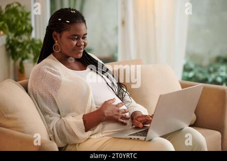 Schwangere Frau, die eine Telemedizinsitzung mit ihrem Arzt hat Stockfoto