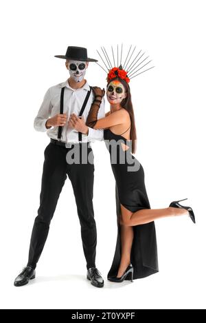 Junges Paar, das für Mexikos Tag der Toten (El Dia de Muertos) auf weißem Hintergrund gekleidet ist Stockfoto