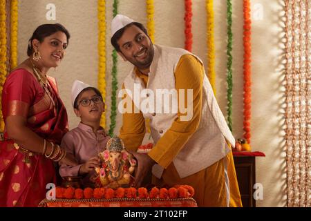 Die Maharashtrianische Familie hält ein Idol von Lord Ganesha Stockfoto