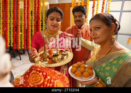 Maharashtrische Familie spielt Ganpati aarti anlässlich von Ganesh Chaturthi Stockfoto