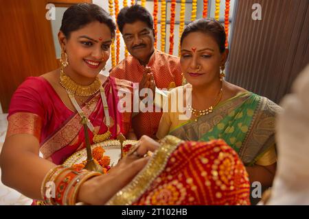 Maharashtrische Familie spielt Ganpati aarti anlässlich von Ganesh Chaturthi Stockfoto