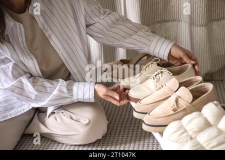 Moderne Frau, die Schuhe wählt, Regalgarderobe Kleiderschrank bequeme Aufbewahrung, die Sicht von oben organisiert Stockfoto