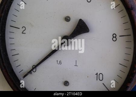 Altes Rundmanometer mit Skala und Pfeilen im Nahbereich. Stockfoto