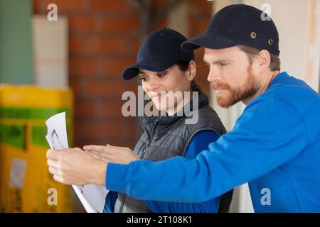 Junge Bauarbeiter betrachten Wohnungspläne Stockfoto