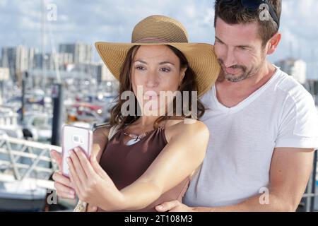 Schönes Paar, das ein Smartphone benutzt, um Selfies zu machen Stockfoto