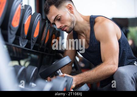 Ein Mann, der eine Hantel aufnimmt Stockfoto