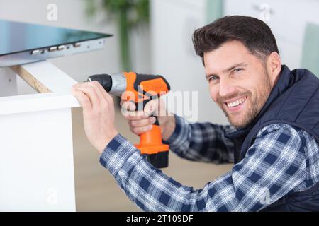 Tischler Bohrer ein Loch mit einer elektrischen Bohrmaschine Stockfoto