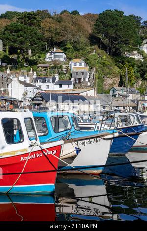 Polperro Inner Harbour, farbenfrohe kleine Fischerboote, die im Hafen dieses kornischen Dorfes, Cornwall, England, Großbritannien, 2023 vor Anker liegen Stockfoto