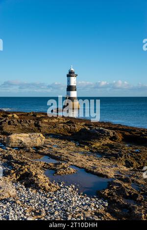 Penmon Point an der Küste von Anglesey, Nordwales. Der berühmte Leuchtturm von Trwyn du bei Morgensonne. Stockfoto