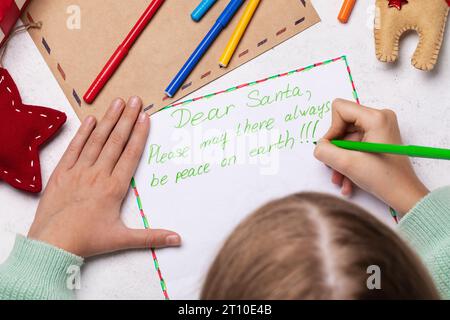 Ein Kind schreibt einen Brief an den Weihnachtsmann, in dem er um Weltfrieden bittet Stockfoto