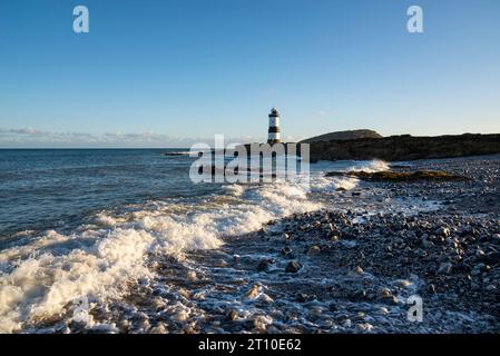 Penmon Point an der Küste von Anglesey, Nordwales. Trwyn du Lighthouse mit Puffin Island dahinter. Stockfoto