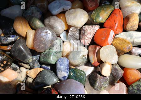 Bunte, glatte Kieselsteine am Strand. Stockfoto