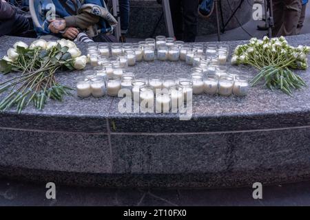 Eine provisorische Gedenkstätte aus Gedenkkerzen in Form von „Start of David“ und Blumen, die bei einer Candlelight Mahnwache für Opfer von Terroranschlägen in Israel auf dem Golda Meir Square in New York City gesehen werden. Am 7. Oktober startete die militante palästinensische Gruppe Hamas von Gaza aus einen Überraschungsangriff auf Israel zu Land, zu Wasser und in der Luft, bei dem über 900 Menschen getötet und mehr als 2000 verletzt wurden. Berichten zufolge wurden auch 130 israelische Soldaten und Zivilisten von der Hamas entführt und nach Gaza gebracht. Der Angriff führte zu einer Kriegserklärung durch den israelischen Premierminister Benjamin Netanjahu und zu einer fortlaufenden Kriegserklärung Stockfoto