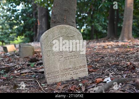 Ein verwitterter Grabstein in einem Winkel auf dem einst verlassenen afroamerikanischen Oberlin Cemetery in Raleigh, North Carolina. Stockfoto