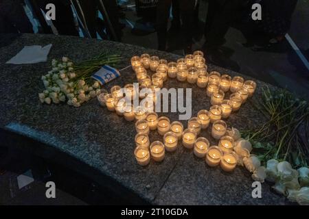 Eine provisorische Gedenkstätte aus Gedenkkerzen in Form von „Start of David“ und Blumen, die bei einer Candlelight Mahnwache für Opfer von Terroranschlägen in Israel auf dem Golda Meir Square in New York City gesehen werden. Am 7. Oktober startete die militante palästinensische Gruppe Hamas von Gaza aus einen Überraschungsangriff auf Israel zu Land, zu Wasser und in der Luft, bei dem über 900 Menschen getötet und mehr als 2000 verletzt wurden. Berichten zufolge wurden auch 130 israelische Soldaten und Zivilisten von der Hamas entführt und nach Gaza gebracht. Der Angriff führte zu einer Kriegserklärung durch den israelischen Premierminister Benjamin Netanjahu und zu einer fortlaufenden Kriegserklärung Stockfoto