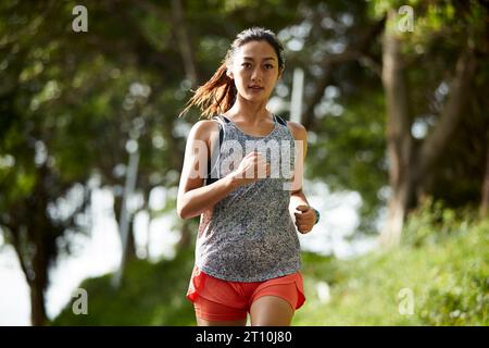 Junge asiatische Joggerin, die im Stadtpark im Freien trainiert Stockfoto