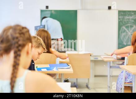 Schülerinnen und Schüler sitzen während des Schulvorlesens im Klassenzimmer Stockfoto