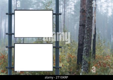 Zwei leere weiße Schilder in einem nebeligen Wald in Finnland. Stockfoto