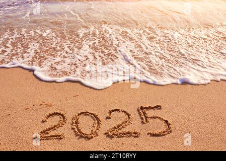 2025 Jahre Zeichnung auf Sandstrand Meer an sonnigem Tag Stockfoto