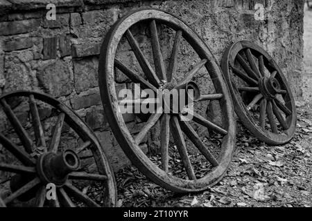 Alte Holzräder stehen an einer Wand. Stockfoto