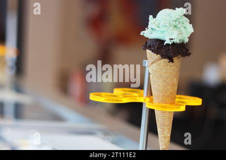 Eiswaffelkegel. Hausgemachtes Eis im Metallhalter. Minz- und dunkles Schokoladeneis. Phistachios-Eis. Kopierbereich. Selektiver Fokus. Stockfoto