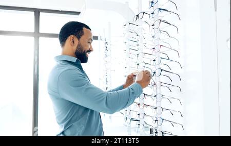 Optometrie speichert Brille und Mann für Entscheidungen, Wahlmöglichkeiten und Augenpflegeoptionen für das Sehen. Gesundheit, Augenheilkunde und Person in der Klinik zu wählen Stockfoto