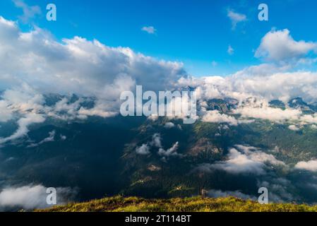 Padona dn Marmolada Berggruppen, die teilweise von Wolken vom Col di Lana Berggipfel in den Dolomiten bedeckt sind, während des Sommervormittags Stockfoto