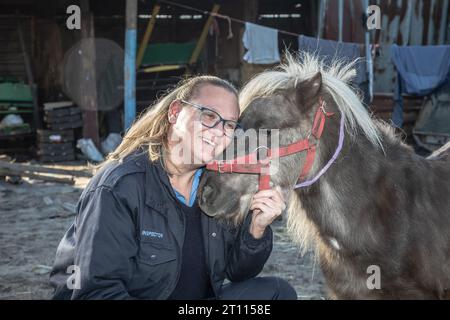 Eine Tierschutzinspektorin teilt einen herzerwärmenden Moment der Verbindung mit einem Miniatur-Pony Stockfoto