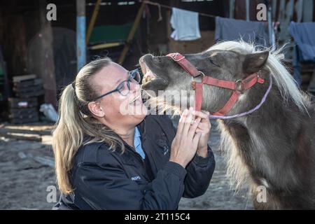 Eine Tierschutzinspektorin teilt einen herzerwärmenden Moment der Verbindung mit einem Miniatur-Pony Stockfoto