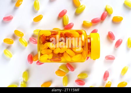 Gummivitamine und Nahrungsergänzungsmittel für Erwachsene. Frau isst süße Gelee Multivitamin Bonbon Mikroelemente aus transparenten Pillen Flasche, modernen Medikamenten und Stockfoto